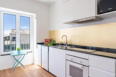 a kitchen with white cabinets and a sink and a window at Casa Amarela Apartments - by Casas na Ilha in Câmara de Lobos