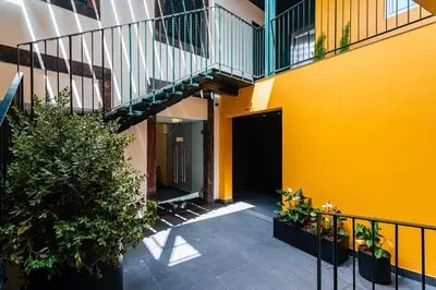 a hallway of a building with a yellow wall and stairs at FLH Viola Market Studios in Funchal