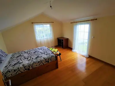 a bedroom with a bed and a dresser and two windows at Casa AIDA SEA VIEW in Relógio do Poiso