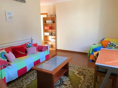 a living room with a colorful couch and a table at Casa AIDA SEA VIEW in Relógio do Poiso