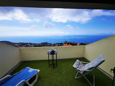 a balcony with a table and chairs and the ocean at Casa AIDA SEA VIEW in Relógio do Poiso
