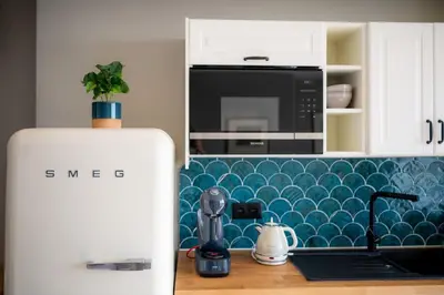 a kitchen with a refrigerator next to a counter at Rooftop Funchal II by Madeira Best Apartments in Funchal