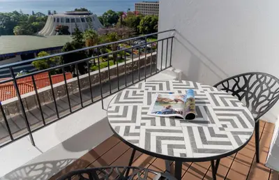 a table and chairs on a balcony with a magazine at Rooftop Funchal II by Madeira Best Apartments in Funchal