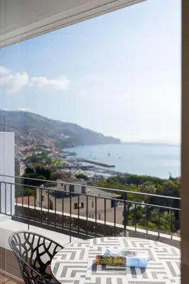 a balcony with a table and chairs and the ocean at Rooftop Funchal II by Madeira Best Apartments in Funchal