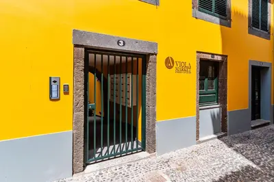 a yellow building with a gate in front of it at FLH Viola Market Flats in Funchal