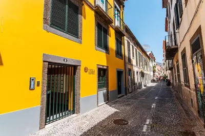 a yellow building on a street in an alley at FLH Viola Market Flats in Funchal