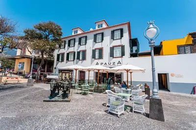 a building with tables and chairs and a street light at FLH Viola Market Flats with Terrace in Funchal