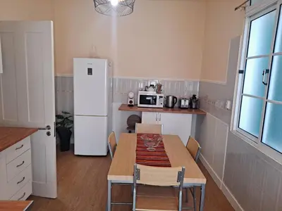 a kitchen with a table and a white refrigerator at Chalé Funchal - City view in Funchal