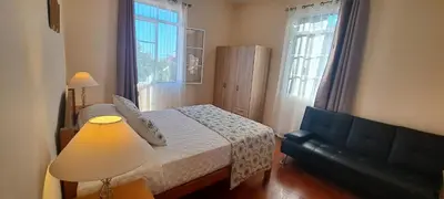 a bedroom with a bed and a lamp and two windows at Chalé Funchal - City view in Funchal