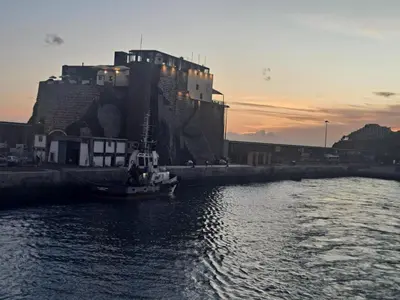 a boat in the water in front of a building at Chalé Funchal - City view in Funchal