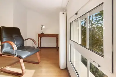 a black chair sitting in front of a window at Casa Amarela in Caniço