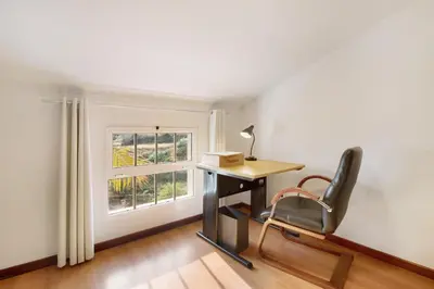 a desk and a chair in a room with a window at Casa Amarela in Caniço