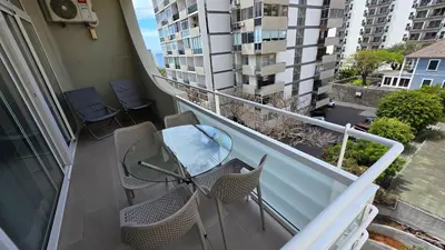 an apartment balcony with a glass table and chairs at Apartamentos Navio Azul in Funchal