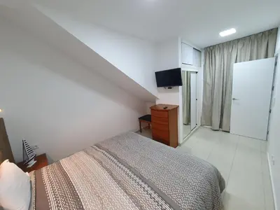 a bedroom with a bed and a dresser and a television at Apartamentos Navio Azul in Funchal