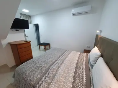 a bedroom with a bed and a flat screen tv at Apartamentos Navio Azul in Funchal