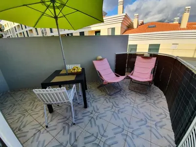a patio with a table and chairs and an umbrella at Apartamentos Navio Azul in Funchal