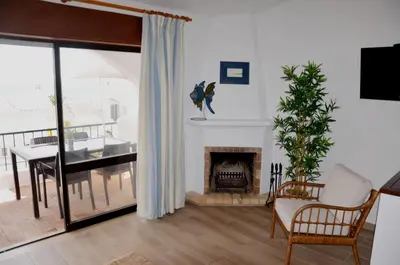 a living room with a fireplace and a dining room at Casa Vista Mar in Luz