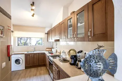 a kitchen with wooden cabinets and a counter top at Casa Vista Mar in Luz