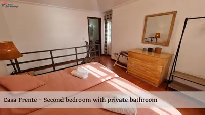 a bedroom with a bed and a dresser and a mirror at Quinta São Lourenço in Fajã da Ovelha