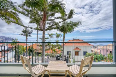 a table and chairs on a balcony with a view of the ocean at Vila Camacho Guest House in Funchal