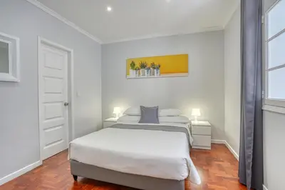 a white bedroom with a bed and two lamps at Vila Camacho Guest House in Funchal