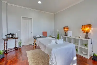 two beds in a room with white walls and wood floors at Vila Camacho Guest House in Funchal