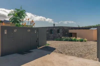 a black garage door with a building in the background at The Rock Villas in Estreito da Calheta