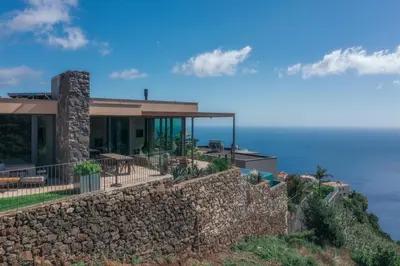a house on top of a stone wall at The Rock Villas in Estreito da Calheta