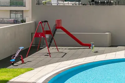 a red slide next to a swimming pool with a pool at Piornais Residence I by An Island Apart in Funchal