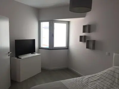 a bedroom with a bed and a television on a dresser at Pool view apartment in Funchal