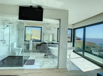 a bathroom with a tub and a tv on the wall at Villa Bahari by LovelyStay in Caniçal
