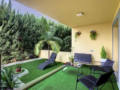 a patio with chairs and a lawn with trees at Samya Apartment by LovelyStay in Funchal