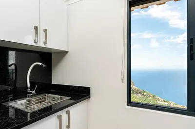 a kitchen with a sink and a large window at Casa Raimunda, Big apartment with amazing views in Arco da Calheta