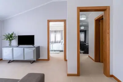 a living room with a tv on a cabinet and a mirror at Casa Raimunda, Big apartment with amazing views in Arco da Calheta