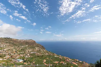 a view of a town on a hill next to the ocean at Casa Raimunda, Big apartment with amazing views in Arco da Calheta