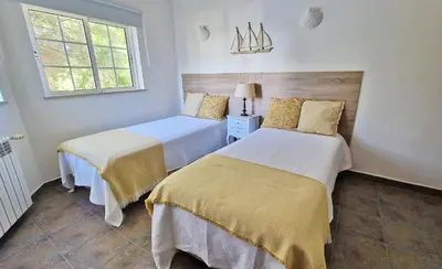 a bedroom with two beds and a window at Queen Palm in Luz
