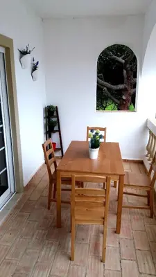 a dining room with a wooden table and chairs at Queen Palm in Luz