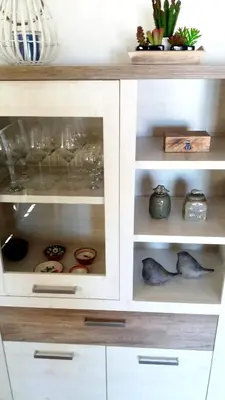 a white cabinet with wine glasses and vases at Queen Palm in Luz