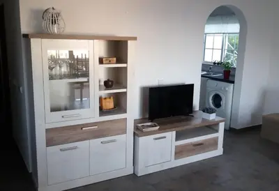 a large white entertainment center with a flat screen tv at Queen Palm in Luz