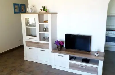 a white entertainment center with a flat screen tv at Queen Palm in Luz