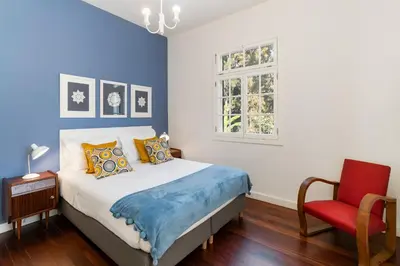 a bedroom with a bed and a red chair at The Yellow House by LovelyStay in Funchal