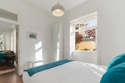a white bedroom with a bed and a window at The Yellow House by LovelyStay in Funchal