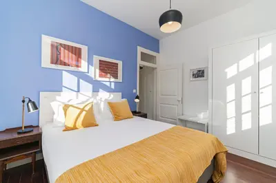 a bedroom with a large bed with a blue wall at The Yellow House by LovelyStay in Funchal