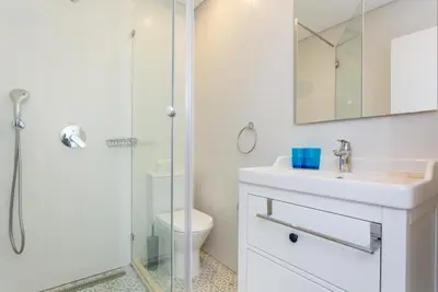 a white bathroom with a shower and a sink at CoolHouses Algarve Luz, 3 Bed Townhouse w/ beautiful sea view, Luz Bay 76 in Luz