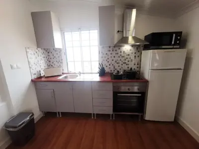 a kitchen with a white refrigerator and a sink at Casa do Curral Velho in Santana