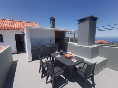 a patio with a table and chairs on a balcony at Casa do Curral Velho in Santana