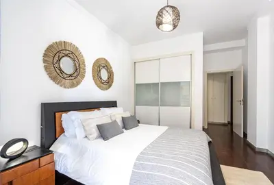 a bedroom with a white bed and a mirror on the wall at City View Apartment by Homie in Funchal