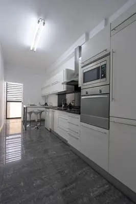 a large kitchen with white appliances and a table at City View Apartment by Homie in Funchal