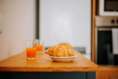 a table with a plate of biscuits and a glass of orange juice at Olinda's Place by Amazing Madeira in Boaventura