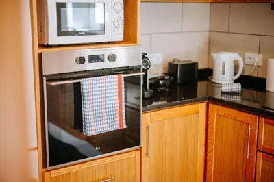 a kitchen with a microwave on top of a oven at Olinda's Place by Amazing Madeira in Boaventura